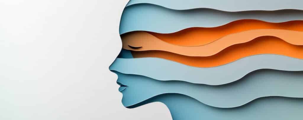 Abstract layered paper cutout of a serene face profile with blue and orange waves